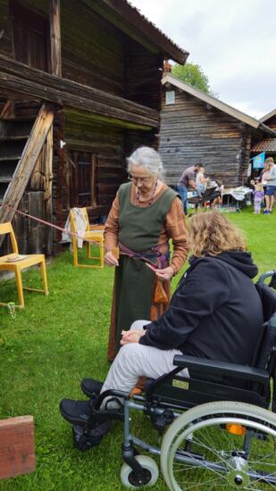 Frau zeigt altes Wikingerhandwerk
